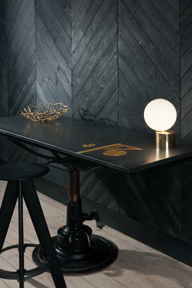 Dark, charred interiors of Metropolitan Wharf by Tom Dixon's Design Research Studio. Featuring a Slab stool and Etch stationery.