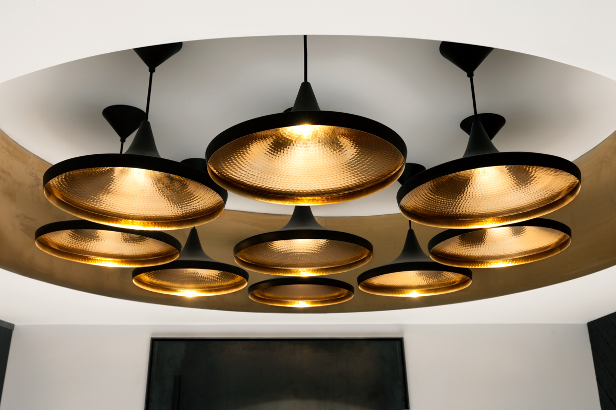A lighting cluster of Tom Dixon's Beat wide pendants in the Metropolitan Wharf interior.